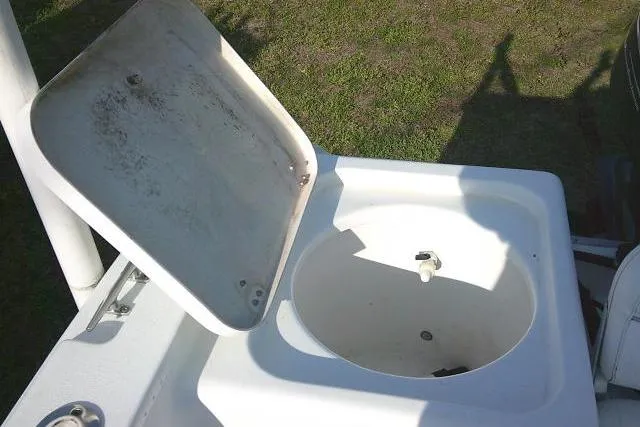 Slide: The Image of 2005 Sea Pro boat livewell with open lid, showing interior and surrounding deck. - 29