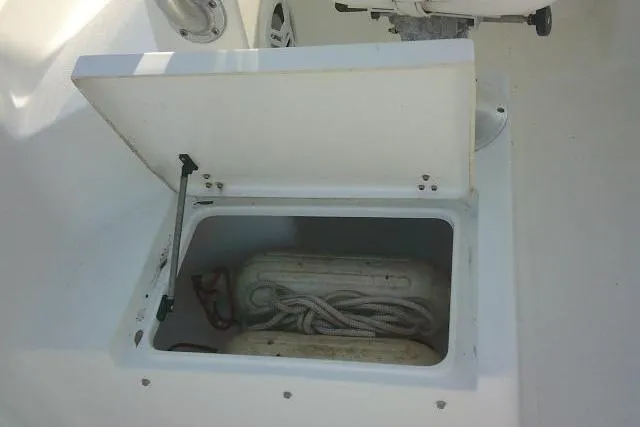 Slide: The Image of Open storage compartment on a 2005 Sea Pro boat, containing coiled rope and equipment. - 39
