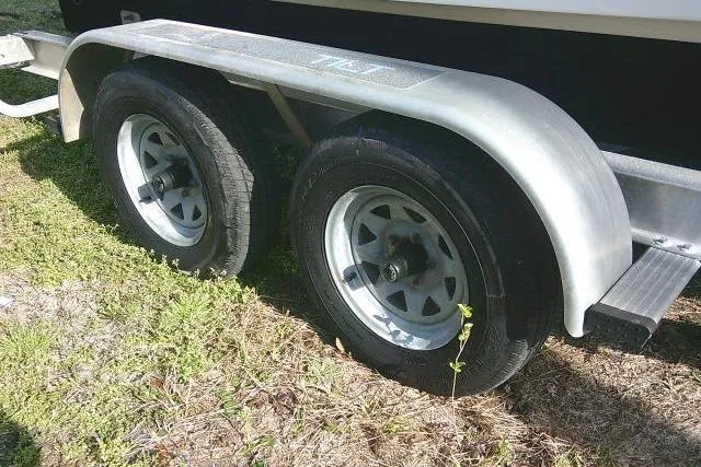 Slide: The Image of 2005 Sea Pro boat trailer with dual wheels on grassy ground. - 6