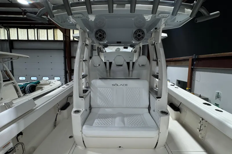 Slide: The Image of 2025 Solace 37CS boat interior with white seating and modern design in a showroom. - 21