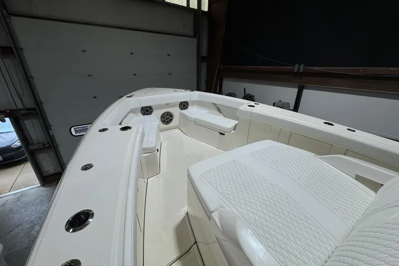 Slide: The Image of 2025 Solace 37CS boat interior with white seating and modern design in a garage setting. - 25