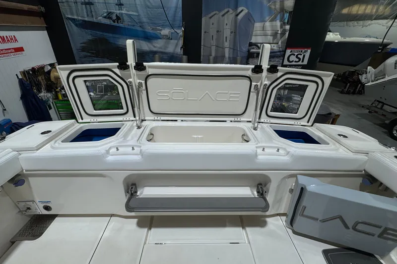 Slide: The Image of 2025 Solace 37CS boat interior with open storage compartments in a showroom setting. - 31