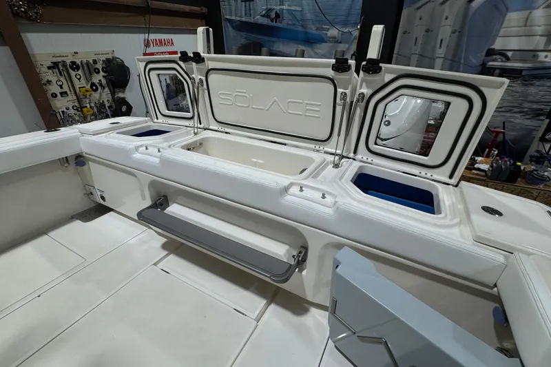 Slide: The Image of 2025 Solace 37CS boat interior with open storage compartments and Yamaha equipment. - 32