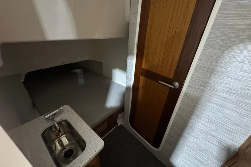 Slide: The Image of Compact cabin interior of 2025 Solace 37CS with sink and wooden door. - 33