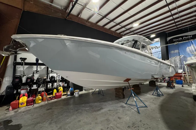 Slide: The Image of 2025 Solace 37CS boat in a workshop, elevated on stands, surrounded by equipment. - 38