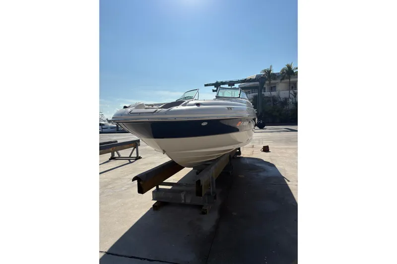 Slide: The Image of 2004 Sea Ray 240 Sundeck boat on a dock under clear blue sky. - 3
