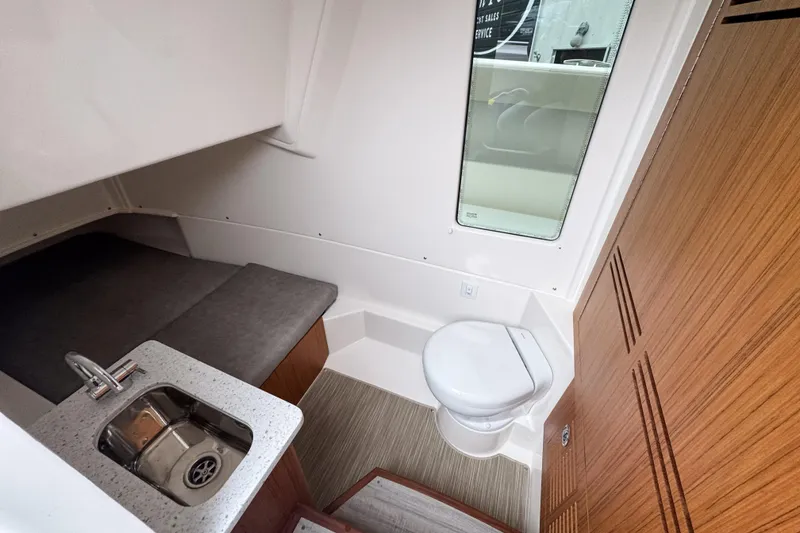 Slide: The Image of Interior of 2025 Solace 30 HCS boat featuring a compact bathroom and sink area. - 18