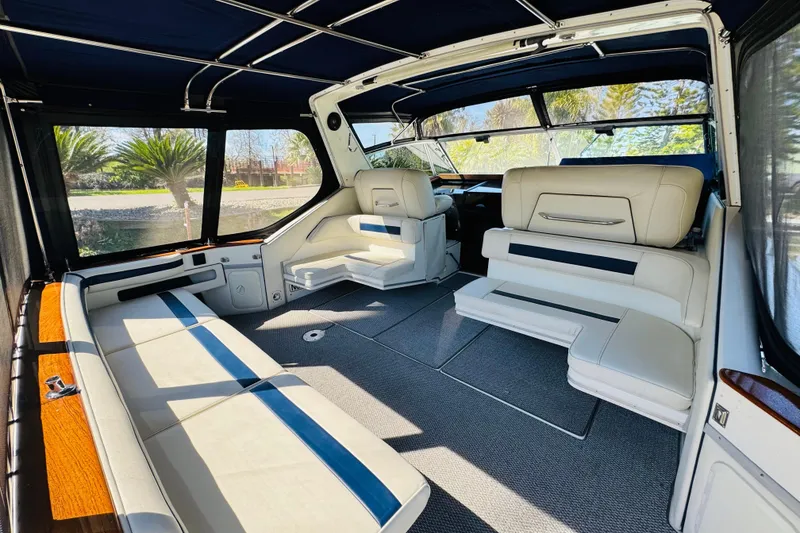 Slide: The Image of 1989 Sea Ray 390 Express Cruiser interior with white seating and blue accents. - 14