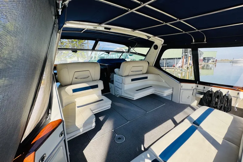 Slide: The Image of 1989 Sea Ray 390 Express Cruiser interior with white seating and marina view. - 15