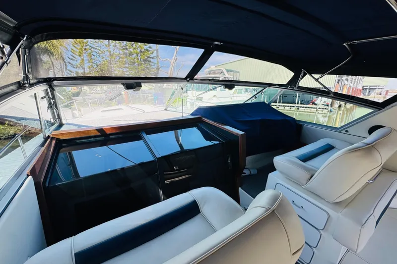 Slide: The Image of Interior view of 1989 Sea Ray 390 Express Cruiser with white seating and dashboard. - 16