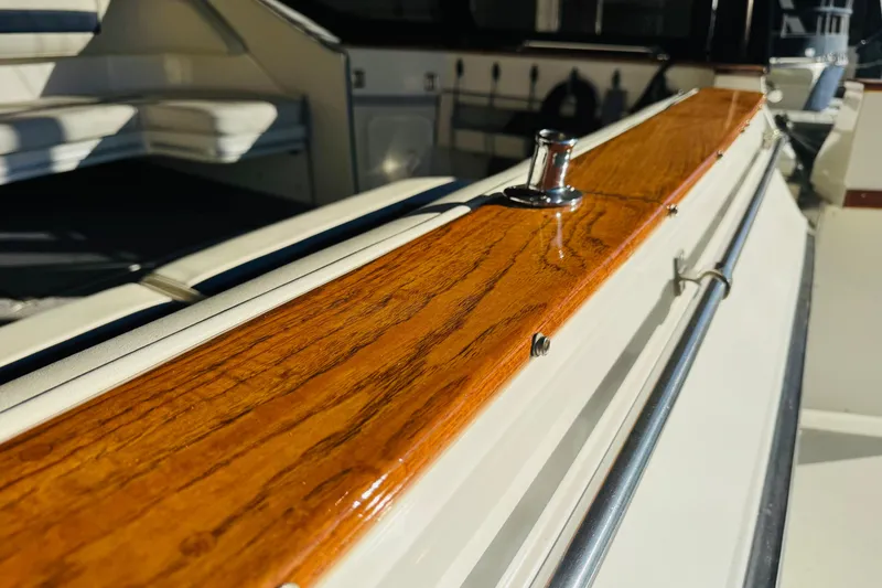 Slide: The Image of 1989 Sea Ray 390 Express Cruiser with polished wood railing and seating area. - 18