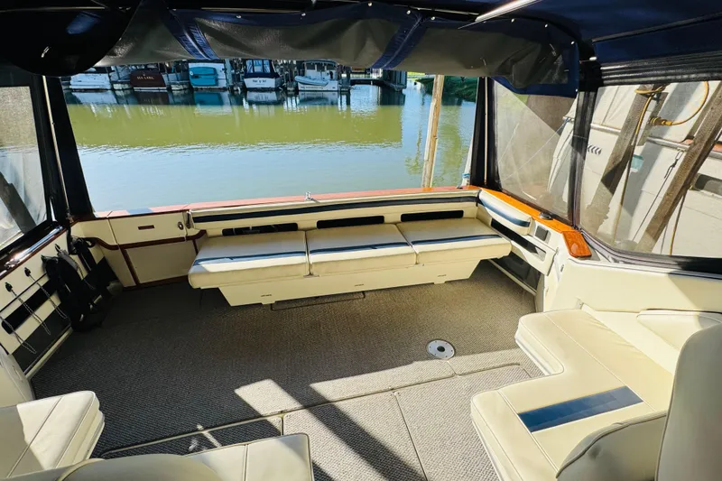 Slide: The Image of 1989 Sea Ray 390 Express Cruiser interior with spacious seating and waterfront view. - 19