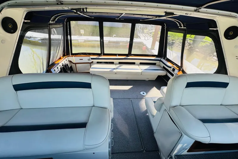 Slide: The Image of 1989 Sea Ray 390 Express Cruiser interior with white seating and large windows. - 26