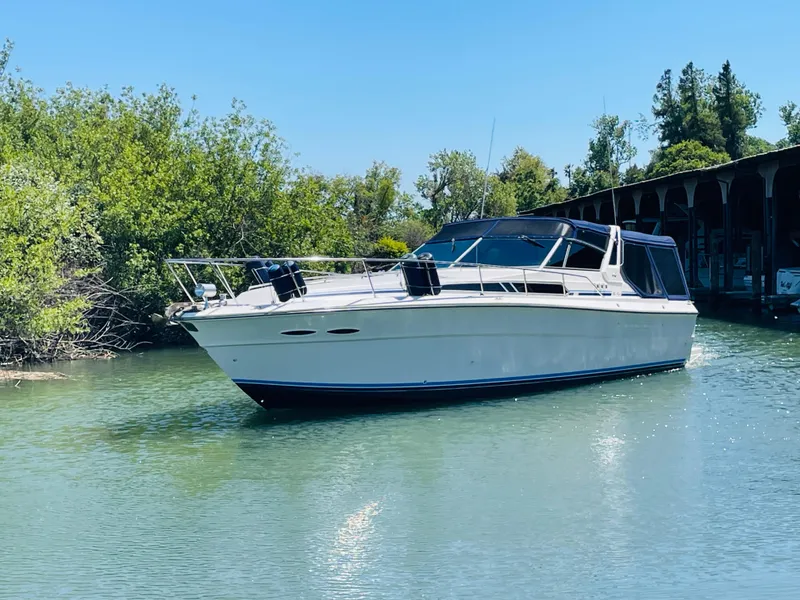 Slide: The Image of 1989 Sea Ray 390 Express Cruiser on calm water. - 4