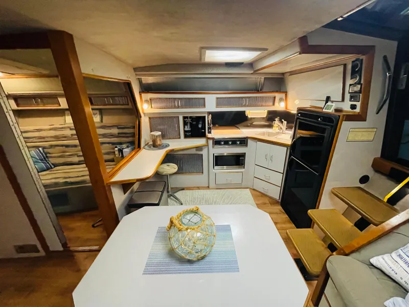 Slide: The Image of Interior of a 1989 Sea Ray 390 Express Cruiser with kitchen and dining area. - 46