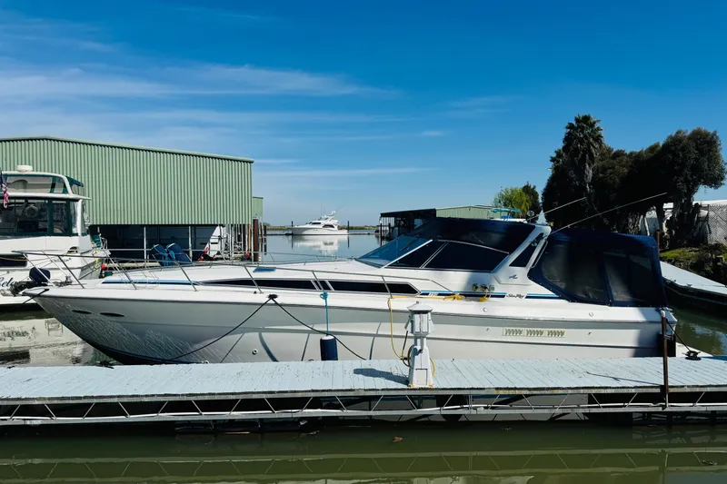 Slide: The Image of 1989 Sea Ray 390 Express Cruiser docked at marina under clear blue sky. - 9