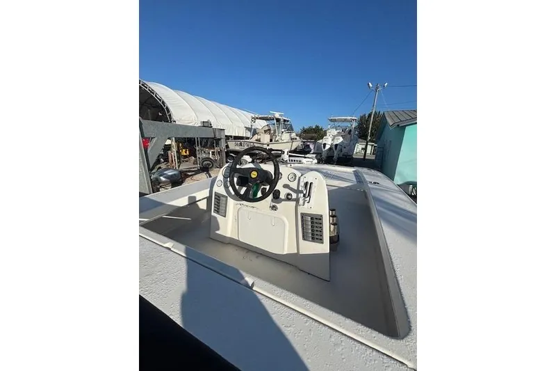 Slide: The Image of 2007 Talon F21 boat dashboard with steering wheel, parked in a marina under clear blue sky. - 12
