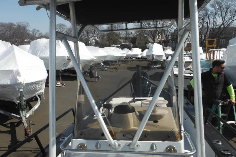 Slide: The Image of 1990 Boston Whaler Guardian 22 in storage yard with covered boats. - 12