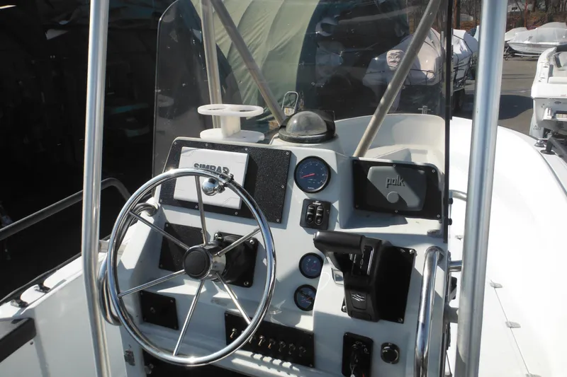 Slide: The Image of 1990 Boston Whaler Guardian 22 boat dashboard with steering wheel and controls. - 18
