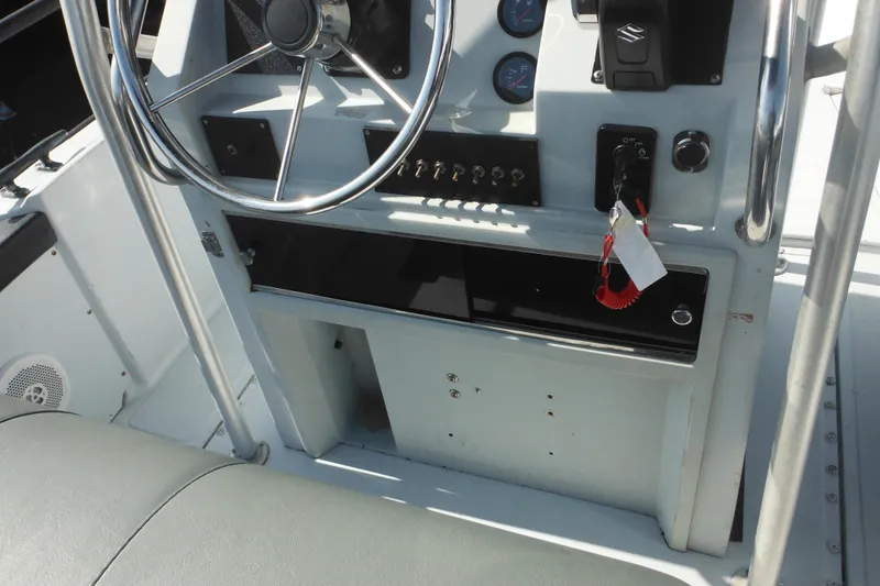 Slide: The Image of 1990 Boston Whaler Guardian 22 boat dashboard with steering wheel and control panel. - 19