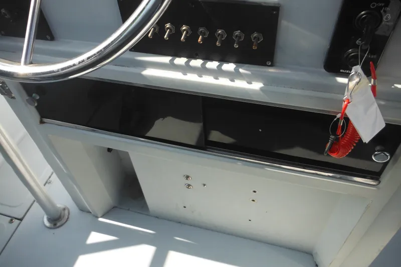 Slide: The Image of 1990 Boston Whaler Guardian 22 boat dashboard with steering wheel and control switches. - 28