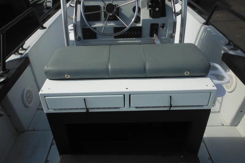 Slide: The Image of 1990 Boston Whaler Guardian 22 boat interior with steering wheel and cushioned seat. - 32