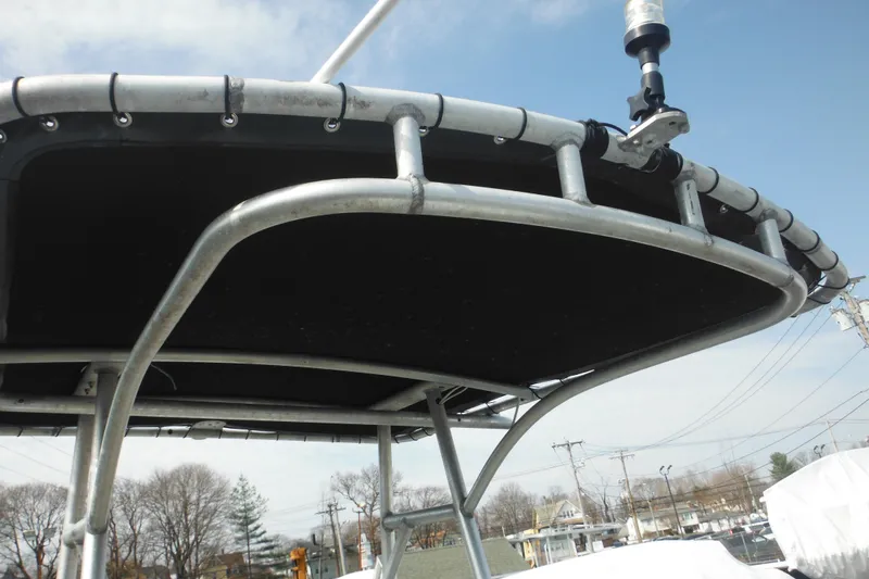 Slide: The Image of 1990 Boston Whaler Guardian 22 T-top frame with mounted equipment, under clear sky. - 37