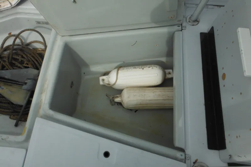 Slide: The Image of Open storage compartment on 1990 Boston Whaler Guardian 22 with ropes and fenders. - 39