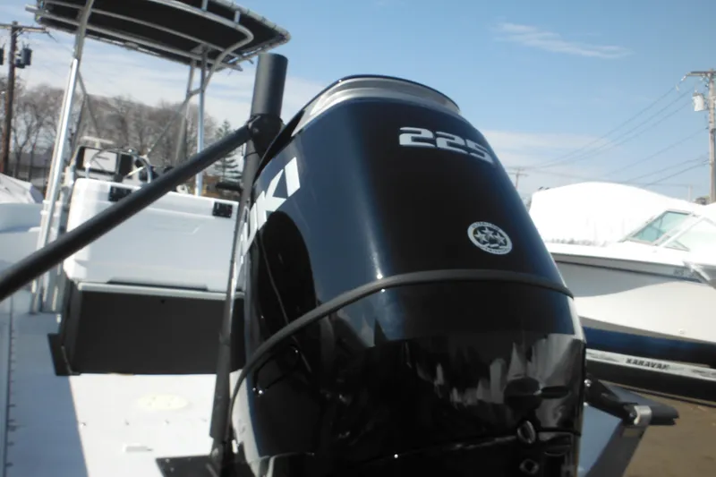 Slide: The Image of 1990 Boston Whaler Guardian 22 with powerful outboard motor, docked under clear skies. - 5