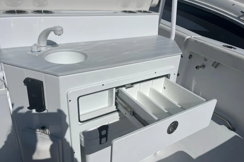Slide: The Image of 2025 Sea Hunt Ultra 265 SE boat interior with sink and storage drawers. - 10