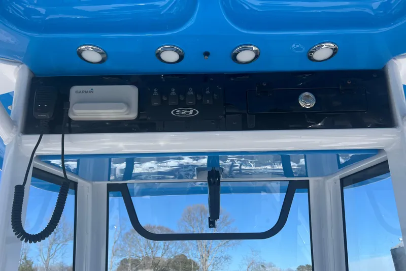 Slide: The Image of 2025 Sea Hunt Ultra 265 SE boat console with Garmin electronics and blue canopy. - 16