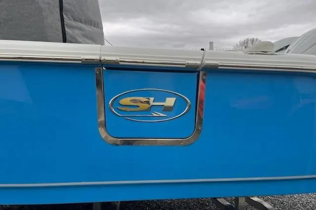 Slide: The Image of Blue Sea Hunt Ultra 265 SE boat, 2025 model, with SH logo on the side. - 2