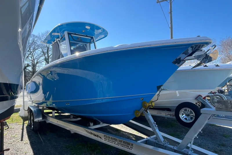 Slide: The Image of 2025 Sea Hunt Ultra 265 SE boat in vibrant blue on a trailer, side view. - 25