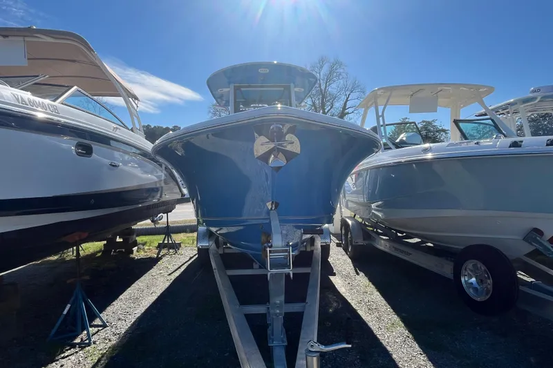 Slide: The Image of 2025 Sea Hunt Ultra 265 SE boat on trailer under clear blue sky. - 26