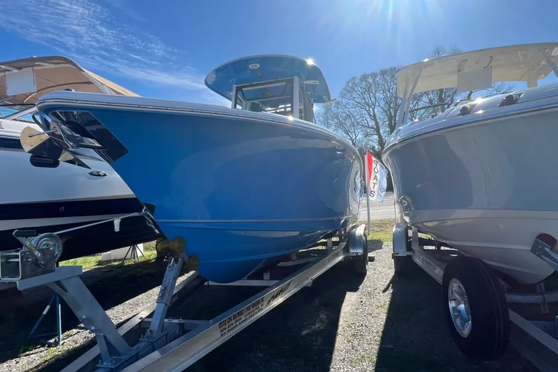 Slide: The Image of 2025 Sea Hunt Ultra 265 SE boat on trailer under clear blue sky. - 27
