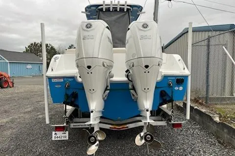 Slide: The Image of 2025 Sea Hunt Ultra 265 SE boat with dual outboard engines, parked outdoors. - 3