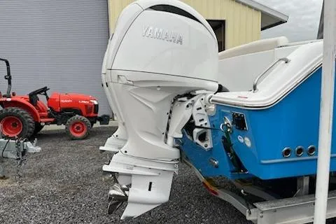 Slide: The Image of 2025 Sea Hunt Ultra 265 SE boat with Yamaha outboard motor, parked near a red tractor. - 5