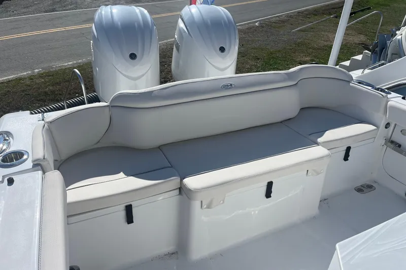 Slide: The Image of 2025 Sea Hunt Ultra 265 SE boat with cushioned seating and dual outboard motors. - 8
