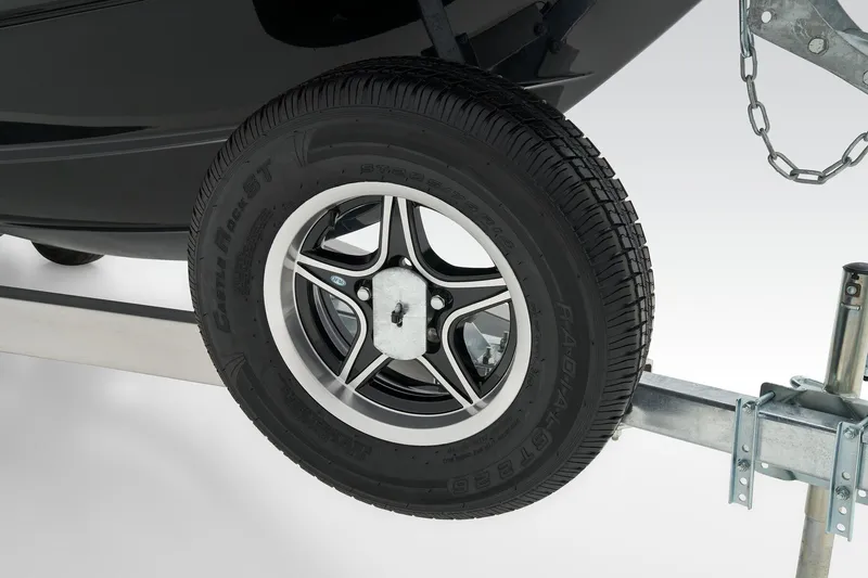 Slide: The Image of Manufacturer Provided Image: 2025 Tahoe T21 trailer wheel and tire detail with black and silver rim. - 16