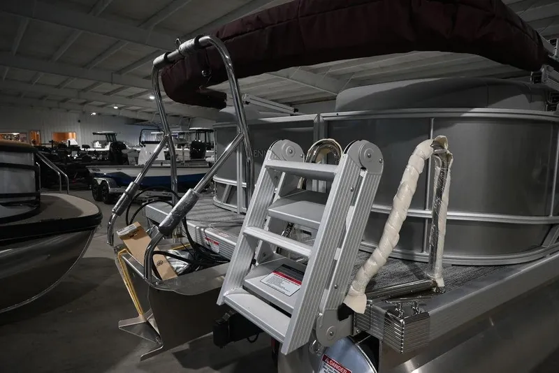 Slide: The Image of 2026 Bennington S Quad Bench 21 SSR pontoon boat with rear ladder in showroom. - 5