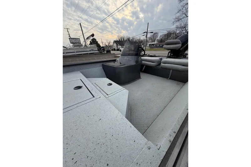 Slide: The Image of 2023 SeaArk 180 RX boat interior with seating and console under cloudy sky. - 2