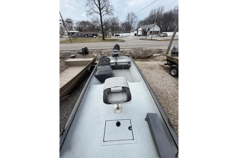 Slide: The Image of 2023 SeaArk 180 RX boat with seating, parked outdoors on gravel. - 3