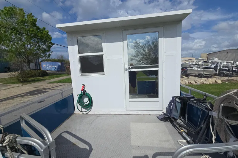 Slide: The Image of 2003 Godfrey model 24 boat with cabin, docked outdoors under a cloudy sky. - 3