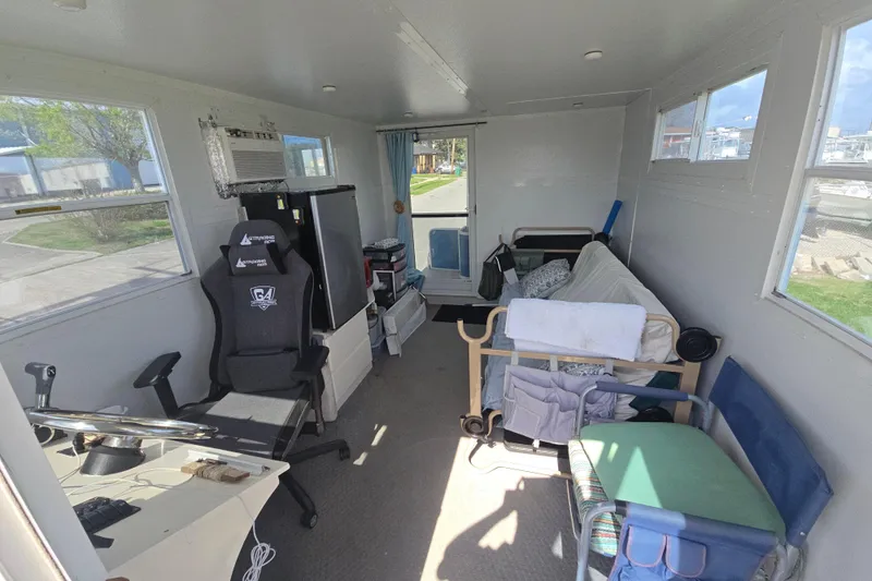 Slide: The Image of Interior of a 2003 Godfrey 24 boat with gaming chair and bed setup. - 4