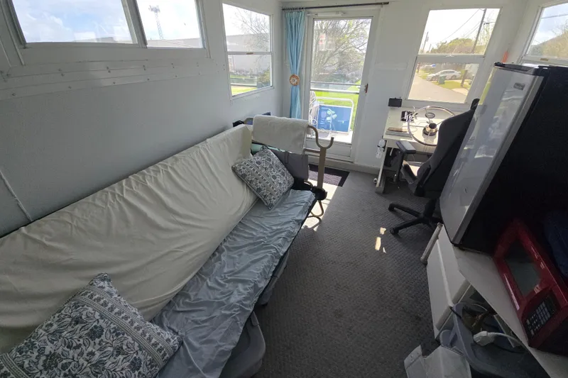 Slide: The Image of Interior of a 2003 Godfrey 24 boat with sofa, steering area, and windows. - 6