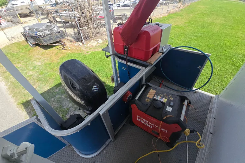 Slide: The Image of 2003 Godfrey 24 boat with Suzuki outboard motor and generator on deck. - 7