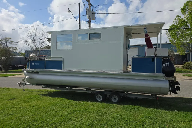 Slide: The Image of 2003 Godfrey 24 pontoon boat with cabin, parked on trailer, under cloudy sky. - 9