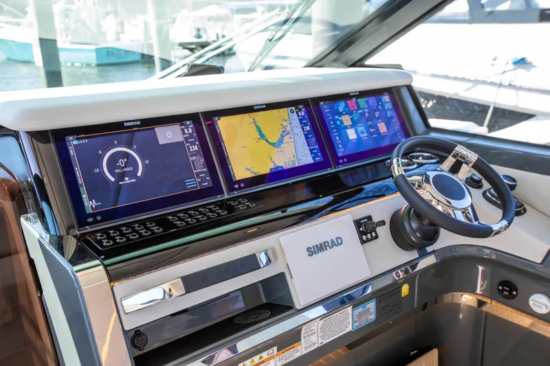 Slide: The Image of The image shows the modern helm of a Saxdor 400 GTC boat with multiple Simrad screens. - 48