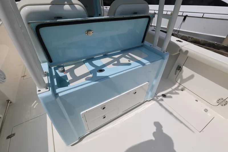 Slide: The Image of 2019 Cobia 320 Center Console boat interior with open storage compartment. - 11