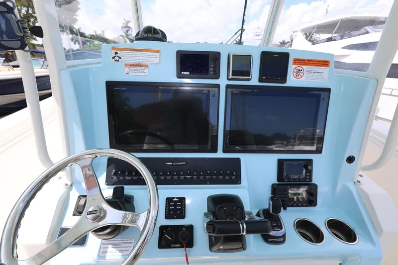 Slide: The Image of 2019 Cobia 320 Center Console dashboard with steering wheel and electronic displays. - 13